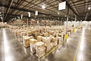Warehouse interior filled with stacked pallets and organized storage, highlighting logistics and warehousing services.