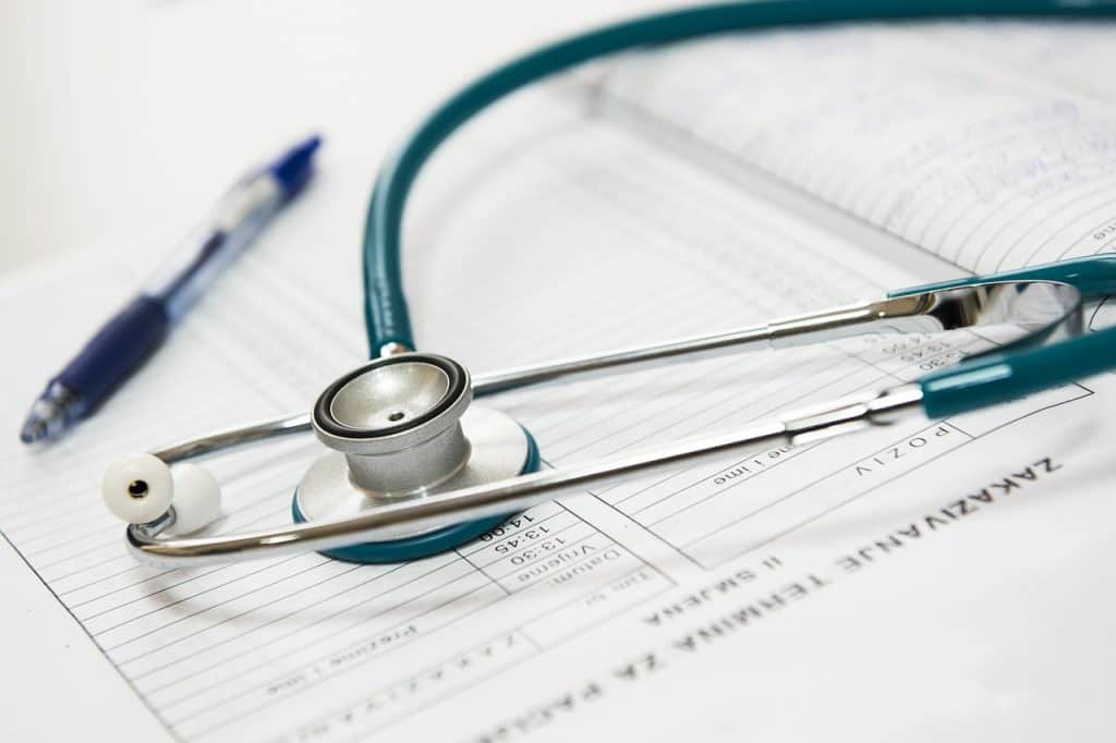 Stethoscope resting on medical paperwork with a pen, symbolizing healthcare supply chain management and effective logistics in the medical field.